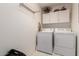 Functional laundry room with modern appliances and convenient overhead storage for essentials at 1362 E Cherry Hills Dr, Chandler, AZ 85249