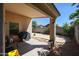 A covered patio with a grill and a spacious backyard surrounded by a block wall at 13959 W Country Gables Dr, Surprise, AZ 85379