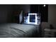 Dimly lit bedroom boasts soft bedclothes and illuminated vanity mirror at 16426 N 49Th St, Scottsdale, AZ 85254
