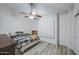 Neutral bedroom featuring light wood flooring, ceiling fan, and large window at 16426 N 49Th St, Scottsdale, AZ 85254