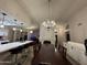 Dining room and eat-in kitchen area with island seating, hardwood floors, and elegant chandeliers at 16426 N 49Th St, Scottsdale, AZ 85254