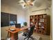 Office with wooden desk, bookcase, and chair on a patterned rug at 16426 N 49Th St, Scottsdale, AZ 85254