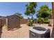 View of backyard featuring a shed, HVAC unit and desert landscaping at 1858 N 128Th Dr, Avondale, AZ 85392