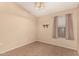 Neutral bedroom featuring neutral walls, window, tile floors and decorative light fixture at 1858 N 128Th Dr, Avondale, AZ 85392
