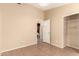 Neutral bedroom featuring neutral walls, closet, tile floors and decorative light fixture at 1858 N 128Th Dr, Avondale, AZ 85392