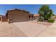 Home exterior with a spacious driveway and low maintenance landscaping under a clear blue sky at 1858 N 128Th Dr, Avondale, AZ 85392