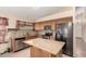 Bright kitchen with stainless steel appliances, tile backsplash, kitchen island and tile flooring at 1858 N 128Th Dr, Avondale, AZ 85392