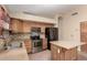 Bright kitchen with stainless steel appliances, tile backsplash, kitchen island, and tile flooring at 1858 N 128Th Dr, Avondale, AZ 85392