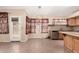 Eat-in kitchen with modern stainless appliances, wood cabinets, a tiled backsplash, and tile floors at 1858 N 128Th Dr, Avondale, AZ 85392