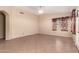 Spacious living room with neutral paint, tile flooring, a vaulted ceiling, and access to backyard at 1858 N 128Th Dr, Avondale, AZ 85392