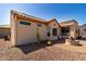 Backyard view featuring desert landscaping, a fire pit, and view of the home's exterior at 20017 N Cielo Ct, Surprise, AZ 85374