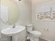 Cozy powder room showcasing pedestal sink, toilet, and beach themed wall art at 20017 N Cielo Ct, Surprise, AZ 85374