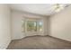 Bright bedroom featuring neutral walls, plush carpet, and a large window at 20017 N Cielo Ct, Surprise, AZ 85374