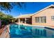 Sparkling pool with tile trim, mature landscaping, and back of house under a clear blue sky at 29670 N 46Th St, Cave Creek, AZ 85331