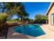 Backyard pool featuring desert landscaping, mature trees, and wrought iron fence at 29670 N 46Th St, Cave Creek, AZ 85331