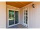 Inviting back porch featuring a sliding glass door and white framed door with a lantern on the exterior at 3433 E Betty Elyse Ln, Phoenix, AZ 85032