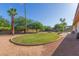 Backyard with a circular lawn, palm trees, and a view of the property with a brick patio at 3433 E Betty Elyse Ln, Phoenix, AZ 85032