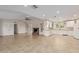Open layout of living room to kitchen featuring a fireplace, a ceiling fan and a lots of natural light at 3433 E Betty Elyse Ln, Phoenix, AZ 85032
