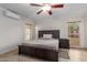 The main bedroom features tile floors, ceiling fan, large windows and dark wood furniture at 3433 E Betty Elyse Ln, Phoenix, AZ 85032
