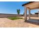 Backyard featuring a covered patio, minimal grass area, and block wall fence at 36025 W Santa Clara Ave, Maricopa, AZ 85138