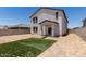 Exterior shot of a two-story home showcasing the spacious backyard with minimalistic turf at 36025 W Santa Clara Ave, Maricopa, AZ 85138