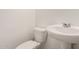 A clean bathroom features a toilet and pedestal sink with chrome fixtures at 36025 W Santa Clara Ave, Maricopa, AZ 85138