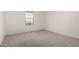 The carpeted bedroom has a window with an external view and white walls at 36025 W Santa Clara Ave, Maricopa, AZ 85138