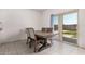 Dining room with a table, four chairs, and a sliding glass door leading to the backyard at 36025 W Santa Clara Ave, Maricopa, AZ 85138