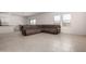 Open-concept living room with tile floors and a large sectional couch at 36025 W Santa Clara Ave, Maricopa, AZ 85138