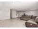 Spacious living room with tile floors, a grey sectional couch, and ample natural light at 36025 W Santa Clara Ave, Maricopa, AZ 85138