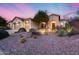 Inviting desert landscaping adorns this home's front exterior with a three-car garage and covered entryway at 42001 N Bridlewood Way, Phoenix, AZ 85086