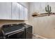 Well-equipped laundry room with front loading washer/dryer and overhead storage cabinets at 42001 N Bridlewood Way, Phoenix, AZ 85086