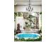 Luxurious bathroom with a unique blue tiled tub, decorative chandelier, and serene garden view at 4316 N 40Th St, Phoenix, AZ 85018