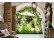 Elegant living room features detailed carved wooden doors that open to a lush, garden-filled outdoor space at 4316 N 40Th St, Phoenix, AZ 85018