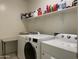 Spacious laundry room with modern washer, dryer, folding table, and shelving at 500 W Nikita Dr, San Tan Valley, AZ 85140