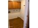 Small laundry room has overhead wooden cabinets and white walls at 6223 N 12Th St # 1, Phoenix, AZ 85014