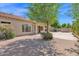 A spacious backyard featuring mature trees and manicured landscaping with a large brick paver patio area at 8354 W Marlette Ave, Glendale, AZ 85305