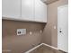 A practical laundry room featuring ample overhead cabinet space and a clean, functional layout at 8354 W Marlette Ave, Glendale, AZ 85305