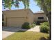 Inviting home exterior featuring a two-car garage, lush landscaping, and desert-style architecture at 9728 N 106Th Pl # 154, Scottsdale, AZ 85258