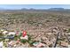 A high-altitude view of a community showing homes and scenic desert landscapes, with a graphic marker at 10119 E Winter Sun Dr, Scottsdale, AZ 85262