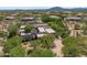Aerial view of a Southwestern-style home surrounded by desert vegetation and mountainous views at 10119 E Winter Sun Dr, Scottsdale, AZ 85262