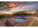 Relaxing hot tub overlooking a sparkling pool and breathtaking sunset creates a luxurious outdoor retreat at 10119 E Winter Sun Dr, Scottsdale, AZ 85262
