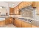 Kitchen with warm wood cabinets, tile backsplash, and stainless steel appliances at 10119 E Winter Sun Dr, Scottsdale, AZ 85262