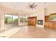 Spacious living room showcasing a fireplace, large windows, and a ceiling fan with tile flooring at 10119 E Winter Sun Dr, Scottsdale, AZ 85262