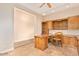 Home office with custom wooden desk and cabinets, and tiled floor at 10119 E Winter Sun Dr, Scottsdale, AZ 85262