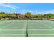 Beautifully maintained tennis and pickleball court with lush landscaping and a shaded gazebo in the background at 10119 E Winter Sun Dr, Scottsdale, AZ 85262