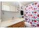 Cozy bathroom features a vanity, toilet, and shower with floral curtain at 10330 W Thunderbird Blvd # C207, Sun City, AZ 85351