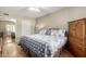 Comfortable bedroom featuring wood floors, neutral walls, and a full sized bed with dresser and mirror at 10330 W Thunderbird Blvd # C207, Sun City, AZ 85351