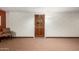 Hallway showcasing a chair, a door with a wreath, and neutral carpet at 10330 W Thunderbird Blvd # C207, Sun City, AZ 85351