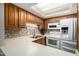 Bright kitchen featuring oak cabinets, modern appliances, and a backsplash with stylish tile at 10330 W Thunderbird Blvd # C207, Sun City, AZ 85351